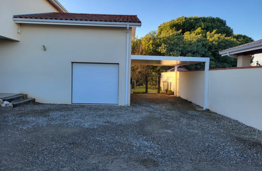 Abri de voitures couleur blanche adossé au mur du garage – Gers proche de Toulouse