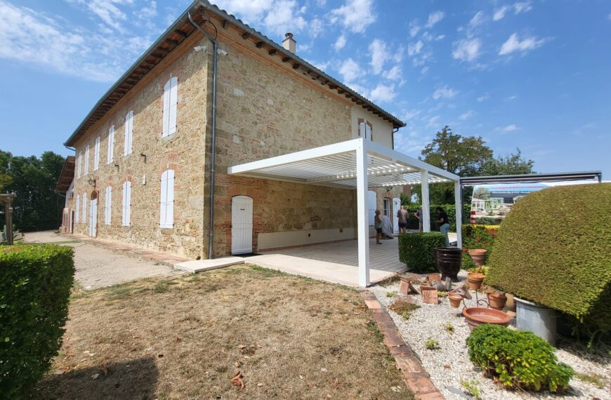 Pergola bioclimatique blanche sur mesure adossée sur maison en pierre – Gers et Toulouse